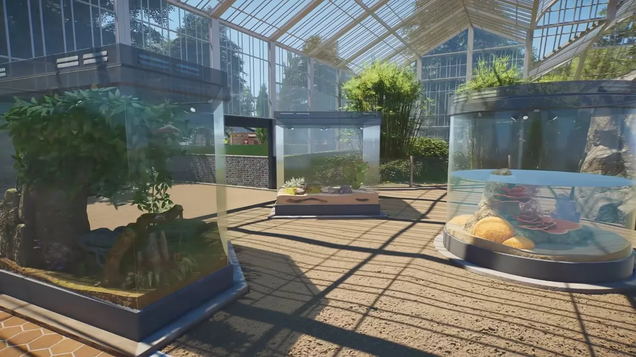 Planet Zoo 2 exhibits with rectangular and cylindrical enclosures inside a greenhouse